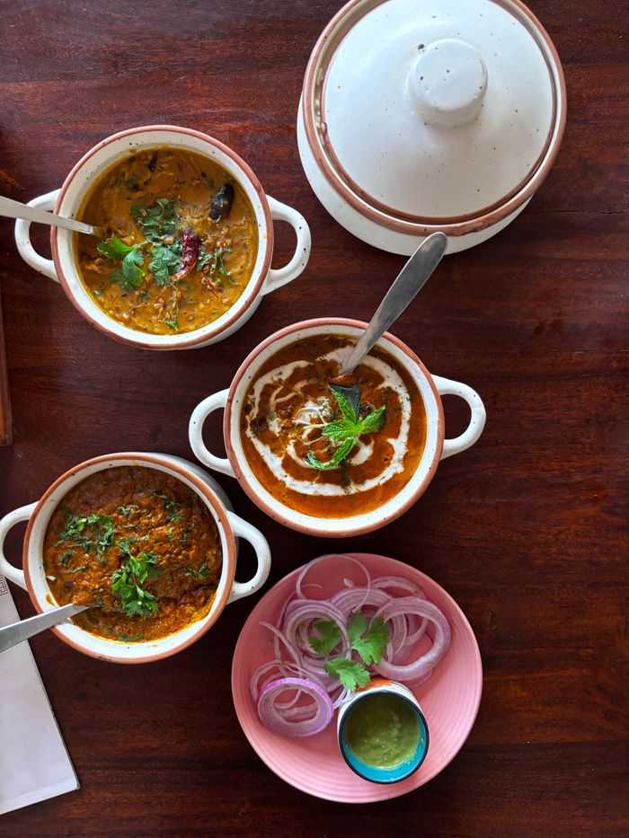 Top view of traditional Indian lentil dishes with spices and garnishes, perfect for culinary use.
